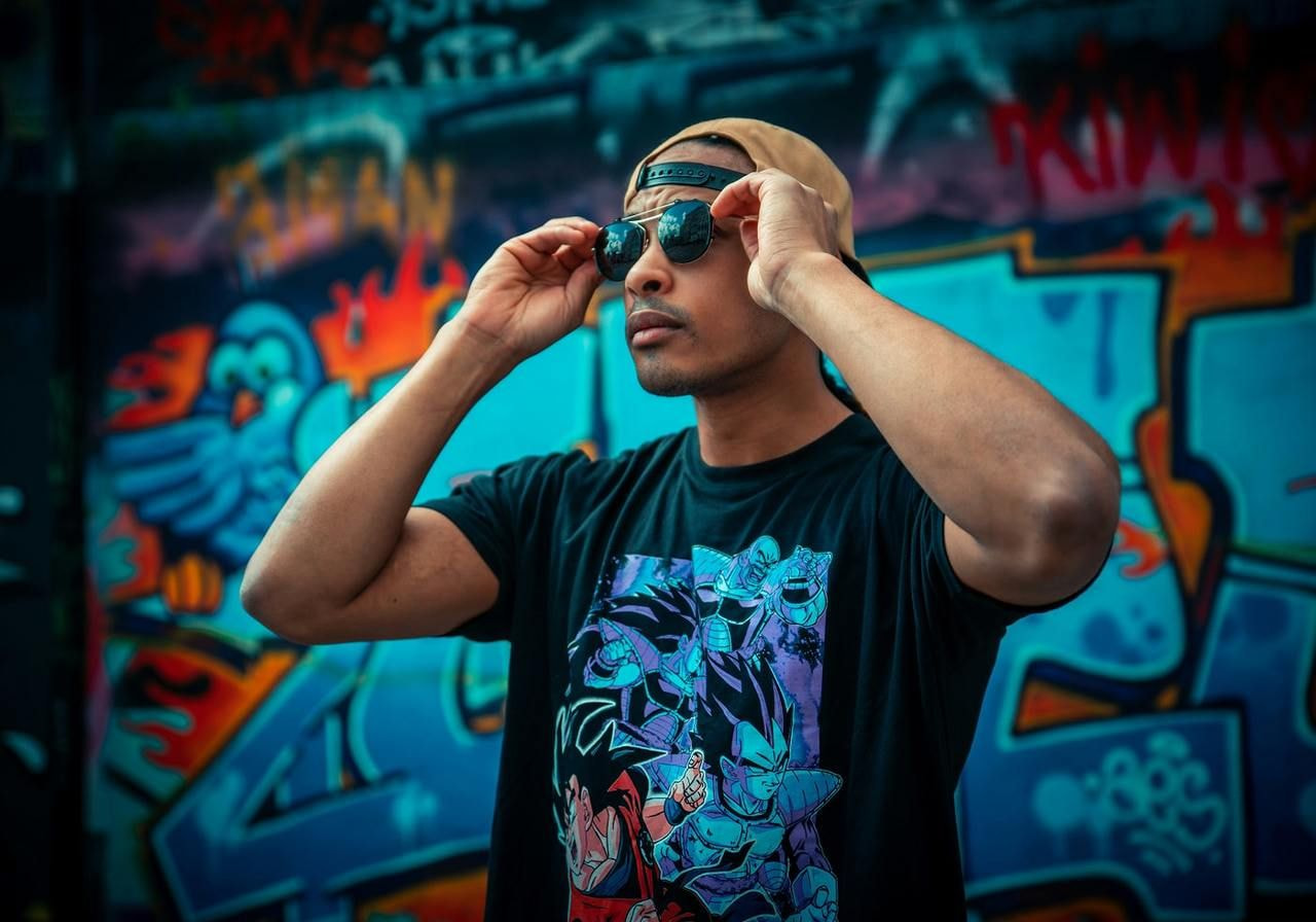 A man wearing a black t-shirt with an anime-themed print on the front.