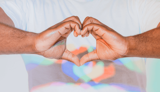 A man holding hands in a heart shape